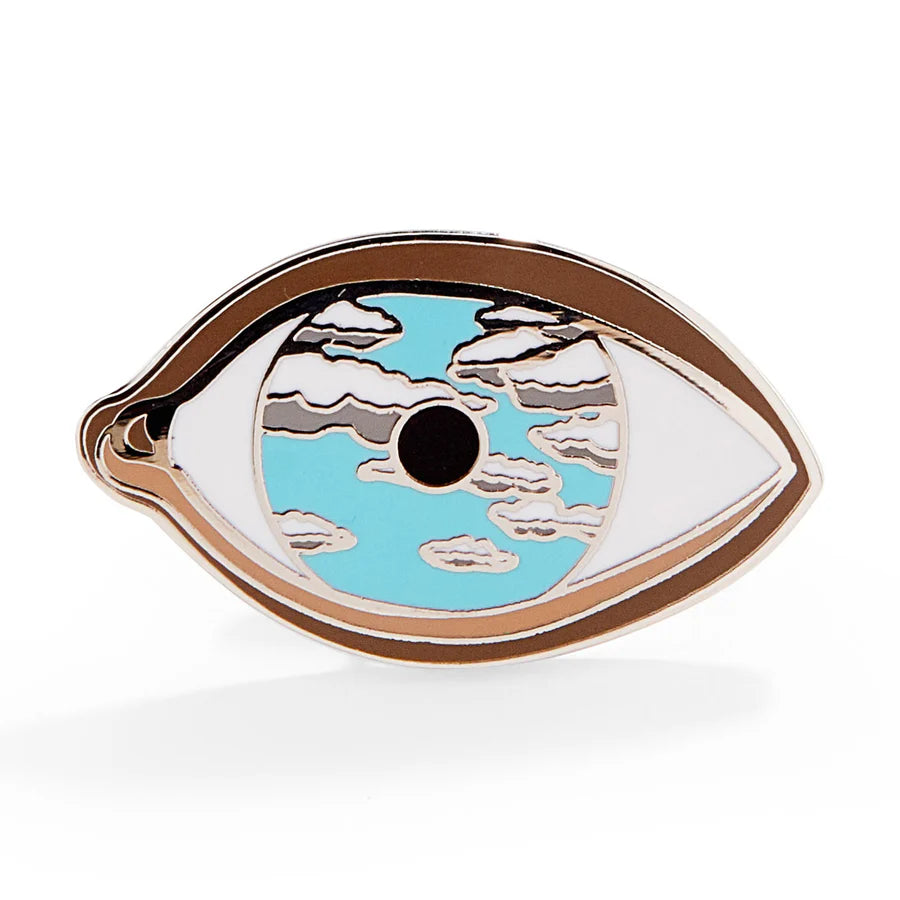 Decorative eye-shaped object with blue center and white edges on a white background
