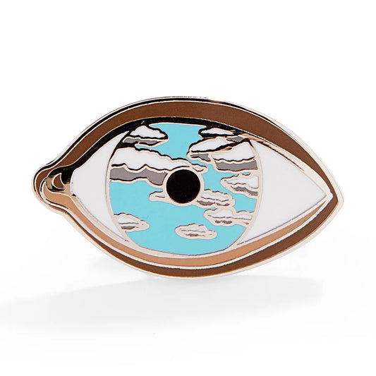 Decorative eye-shaped object with blue center and white edges on a white background