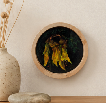 Round framed artwork with yellow leaves on a neutral background